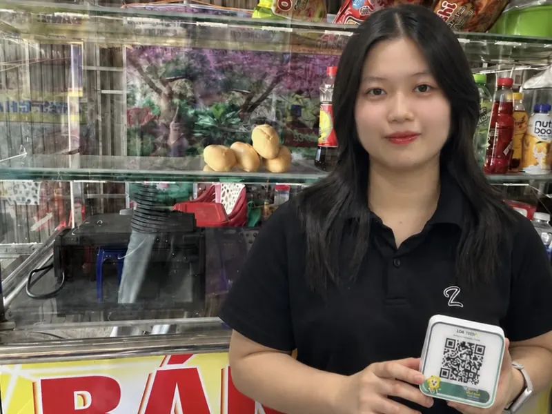 Chị Thuý Hằng, chủ xe bánh mì TUHA, cầm loa Loa X có mã QR thanh toán